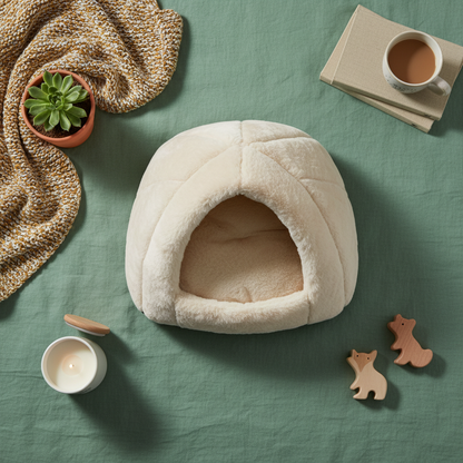 CozyDen cave bed flat lay with cozy home accessories on sage green background